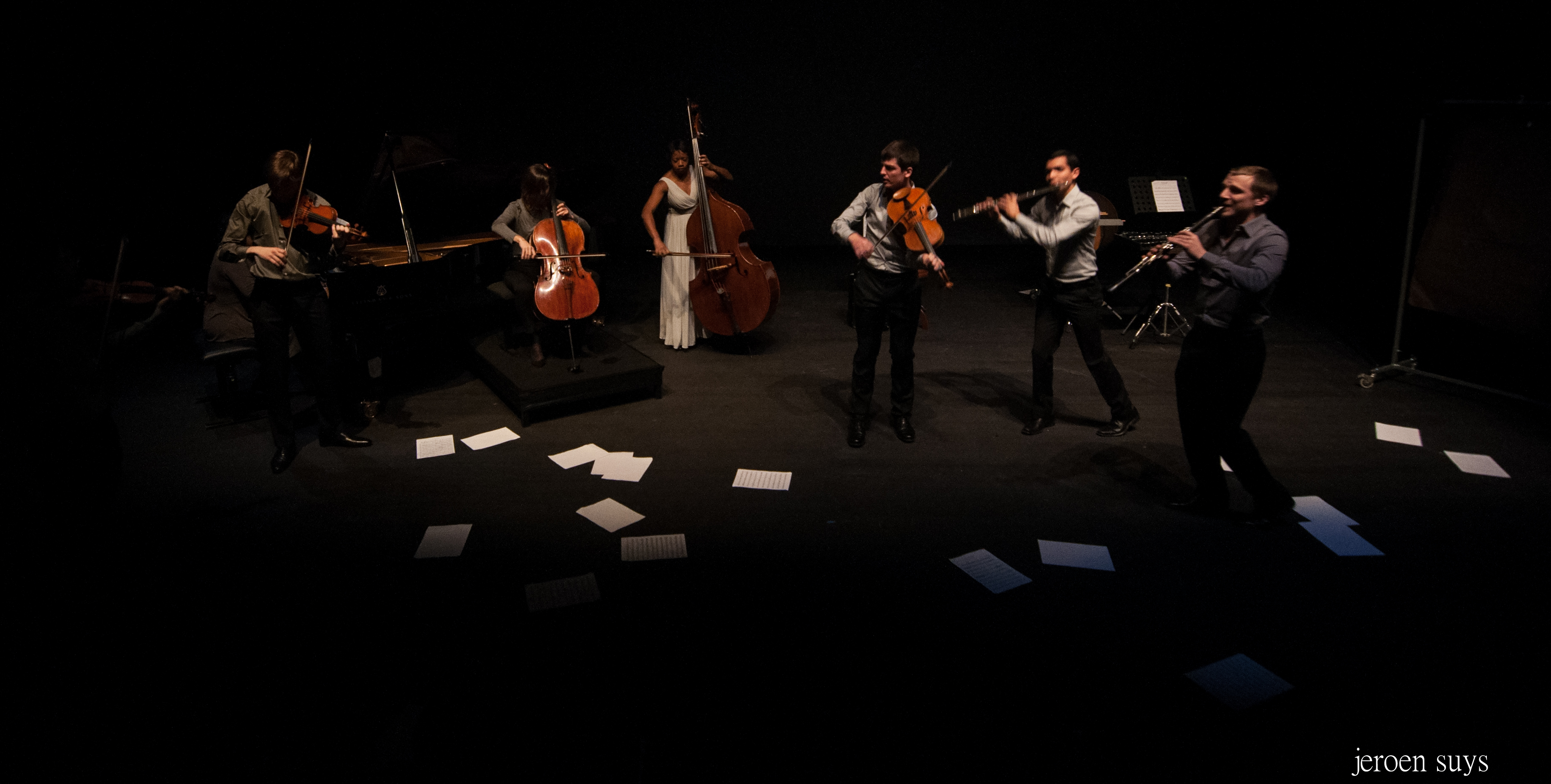 Musiciens jouant devant un sol jonché de partitions